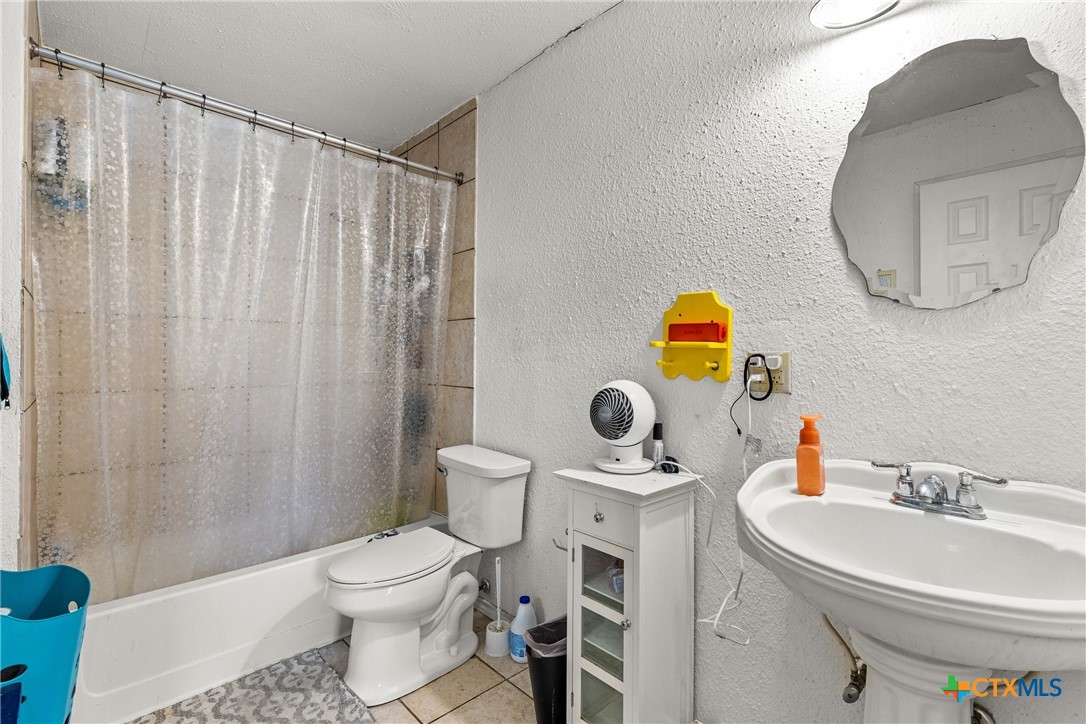 425 Old Pleasanton Road Poteet, TX 78065 - Photo 20 of 38 a bathroom with a sink a toilet and a mirror