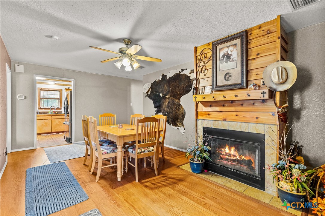 425 Old Pleasanton Road Poteet, TX 78065 - Photo 8 of 38 a dining room with furniture a fireplace and wooden floor