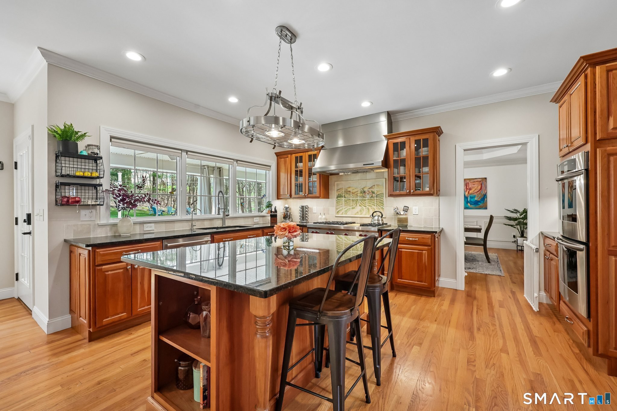 3 East Lake Road Danbury, CT 06811 - Photo 14 of 37 A large bank of windows fills the kitchen with natural light while visually extending the space to the back patio, creating a bright and seamless indoor-outdoor connection.