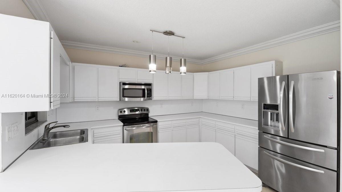 1140 Southwest 85th Court Miami, FL 33144 - Photo 5 of 13 a kitchen with stainless steel appliances a refrigerator sink and microwave