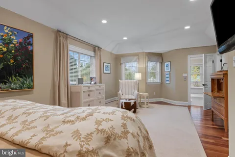 a spacious bedroom with a bed and wooden floor