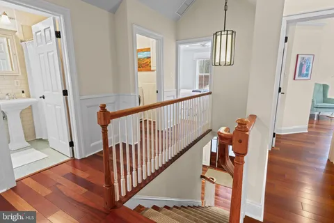 a view of a hallway with wooden floor and stairs