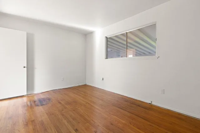 a view of a room with wooden floor and a bathroom