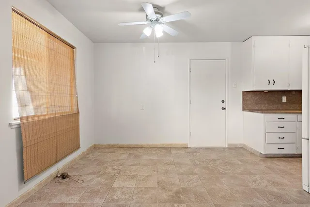 a view of an empty room with window and cabinet