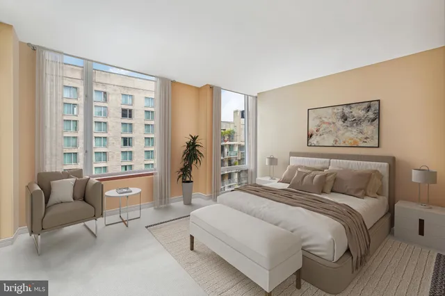 a bedroom with a bed couch and a large window