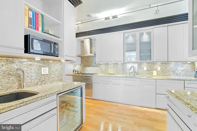 a kitchen with granite countertop cabinets stainless steel appliances and a sink