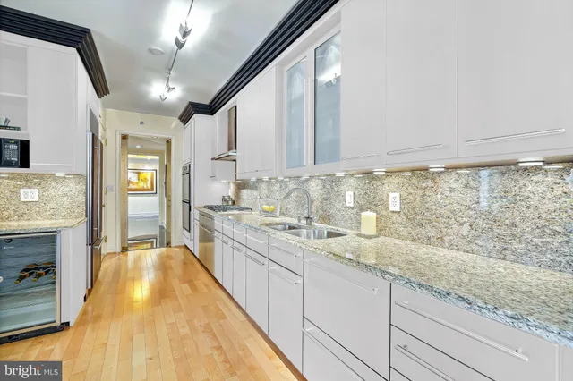 a large kitchen with granite countertop a sink stainless steel appliances and cabinets
