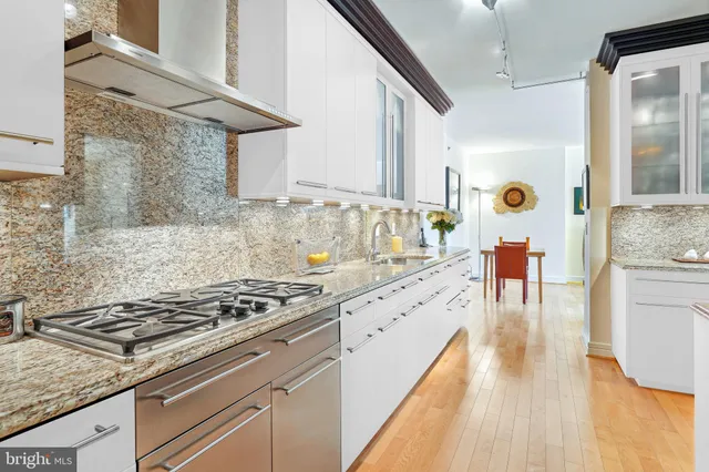 a kitchen with stainless steel appliances granite countertop a stove and a wooden floors