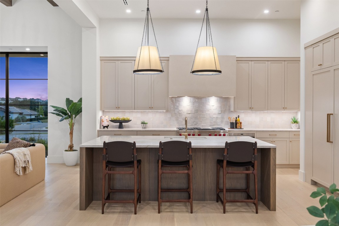5813 Horizon Vista Way Austin, TX 78738 - Photo 17 of 38 a kitchen with granite countertop a sink a stove and chairs