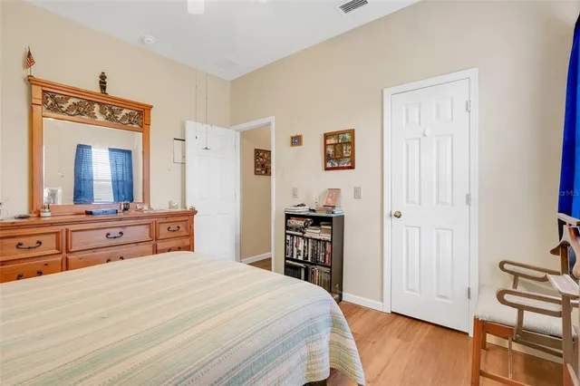 a bedroom with a bed and a dresser with mirror