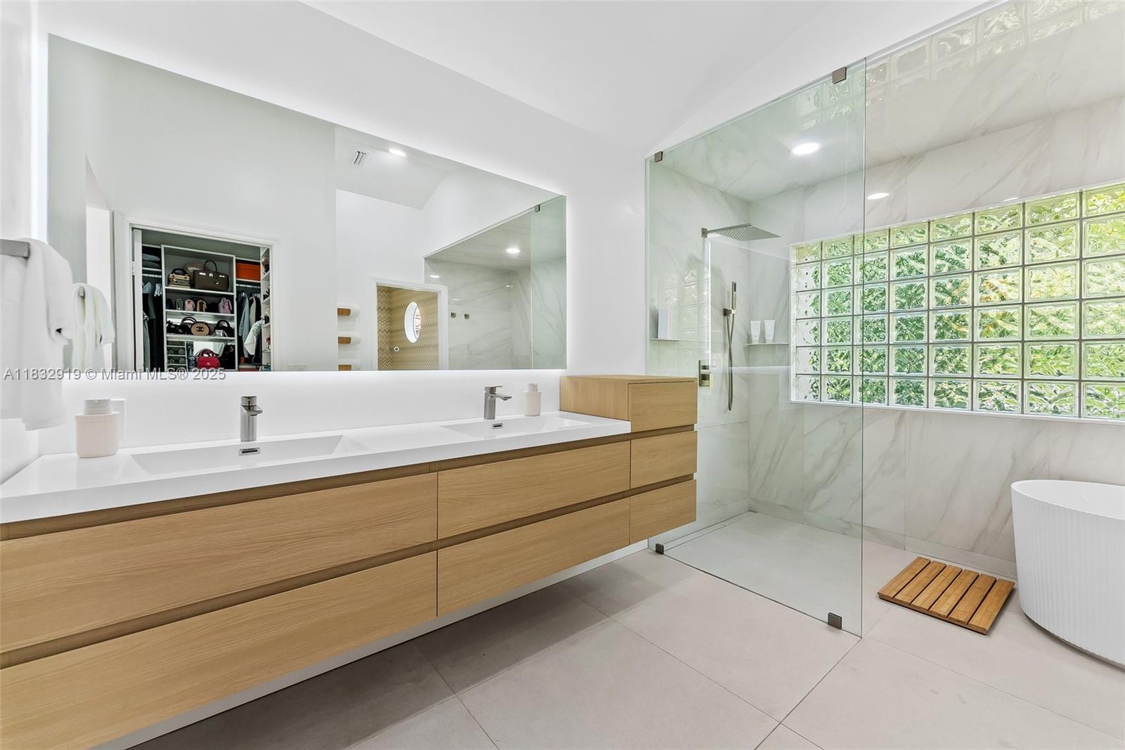17723 Tiffany Trace Drive Boca Raton, FL 33487 - Photo 33 of 44 a bathroom with a double vanity sink a mirror and a bathtub