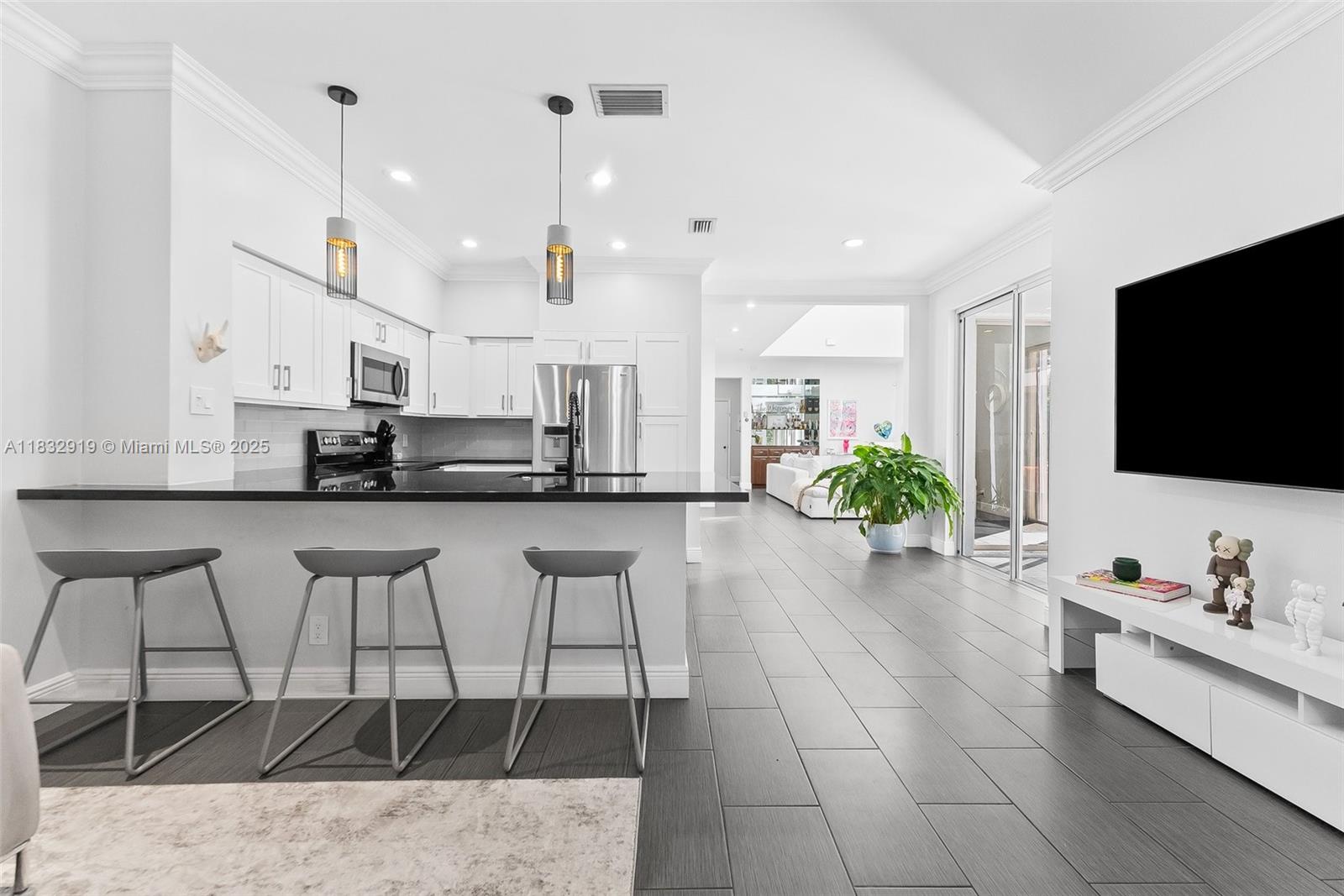 17723 Tiffany Trace Drive Boca Raton, FL 33487 - Photo 9 of 44 a living room with stainless steel appliances kitchen island granite countertop a sink a stove and a flat screen tv