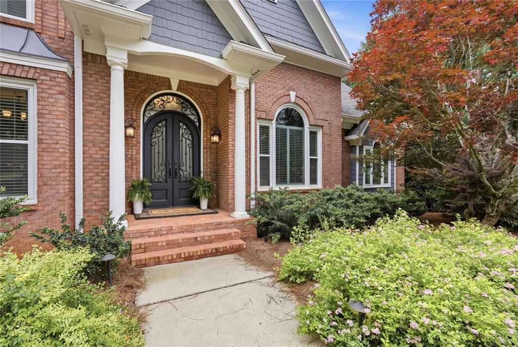 215 Bayfield Court Milton, GA 30004 - Photo 3 of 62 a view of a house with brick walls and flower plants