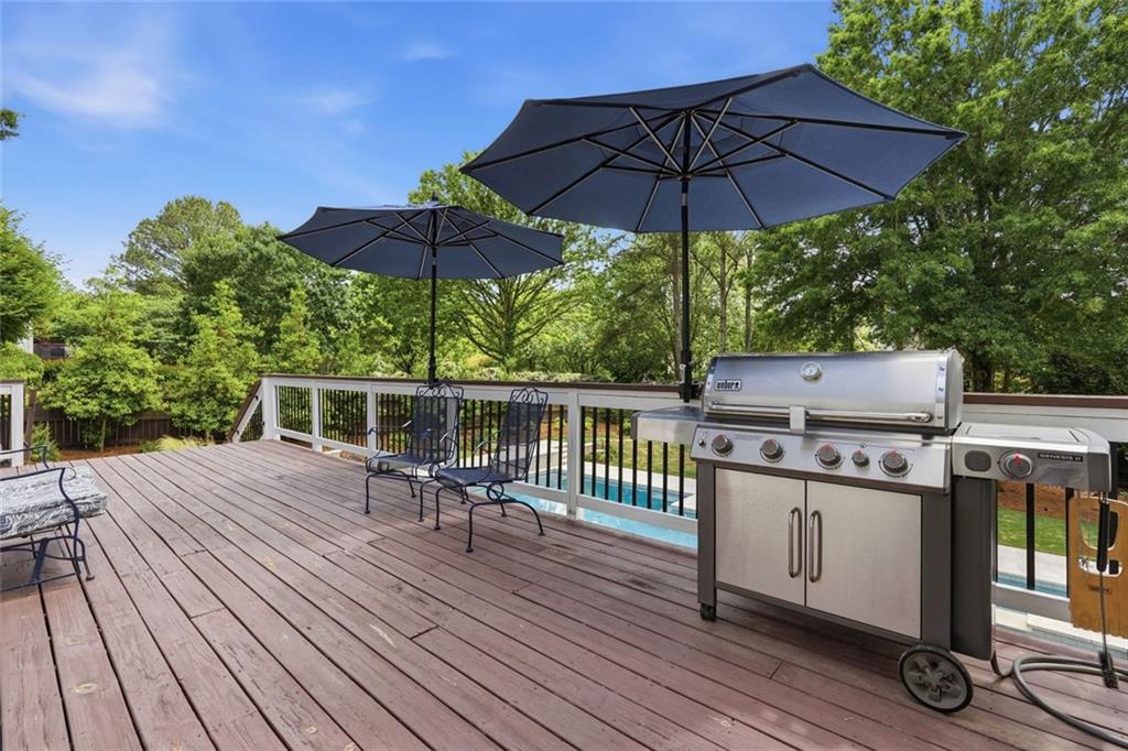 215 Bayfield Court Milton, GA 30004 - Photo 48 of 62 a wooden deck with furniture and umbrella