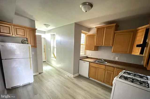 a kitchen with stainless steel appliances granite countertop a refrigerator a stove a sink and a microwave