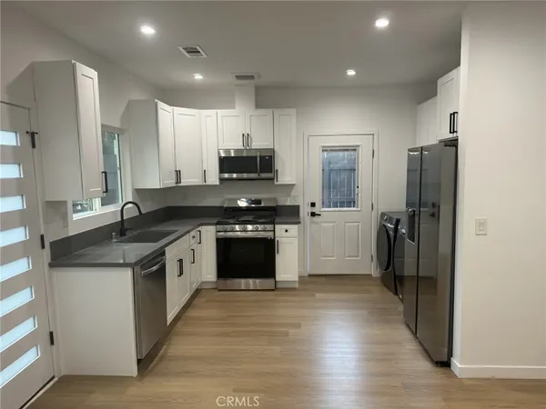 a large kitchen with stainless steel appliances granite countertop a stove a sink and a refrigerator