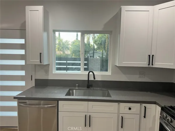 a kitchen with stainless steel appliances granite countertop a sink and a window
