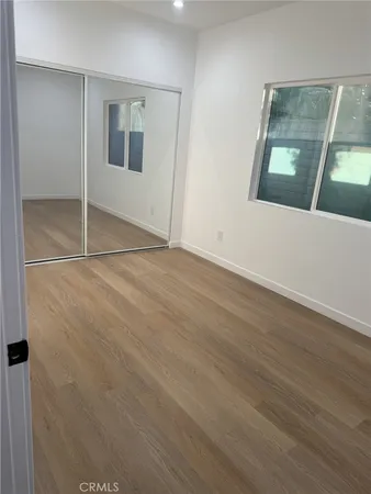 an empty room with wooden floor and mirror