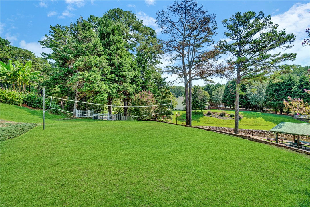 114 Summersweet Lane Seneca, SC 29672 - Photo 20 of 25 Mature trees frame a sprawling, manicured green lawn ideal for outdoor recreation.