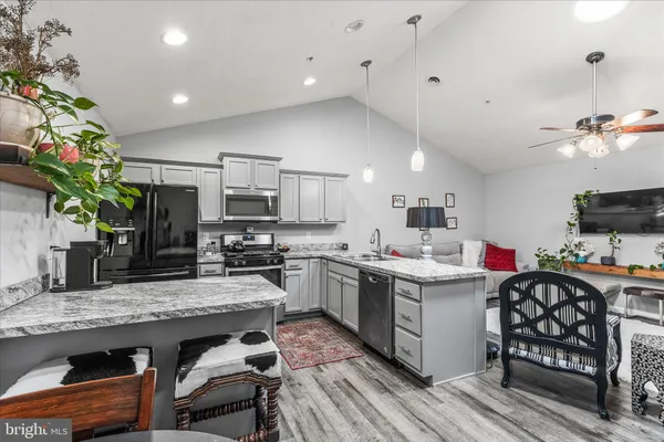 a kitchen with granite countertop a sink a counter space appliances and cabinets