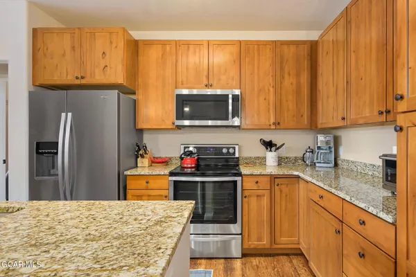 a kitchen with stainless steel appliances granite countertop a refrigerator stove and sink