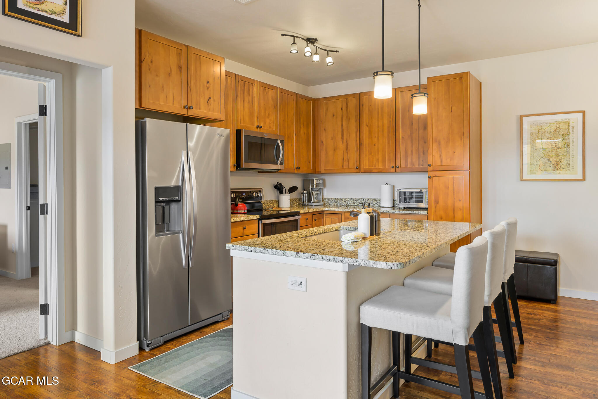164 Village Road, Unit H203 Granby, CO 80446 - Photo 14 of 38 a kitchen with stainless steel appliances granite countertop a refrigerator a sink a stove a dining table and chairs