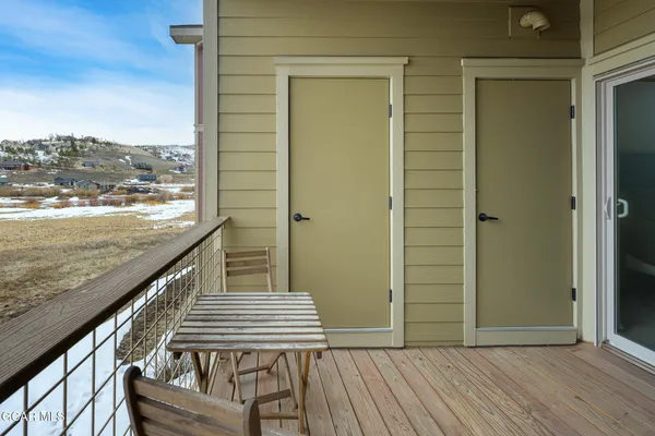 a view of a balcony with wooden floor and bench