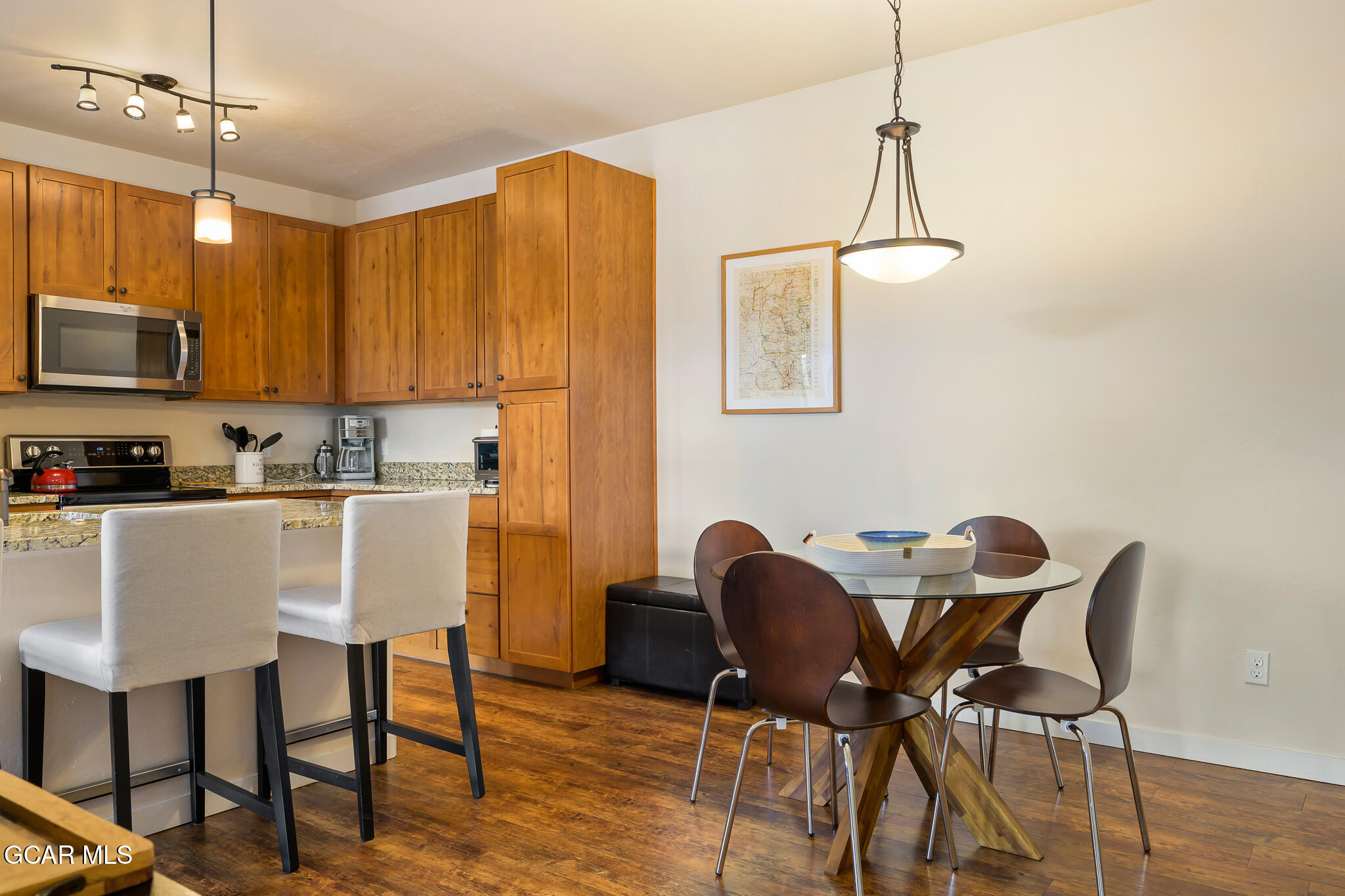164 Village Road, Unit H203 Granby, CO 80446 - Photo 5 of 38 a kitchen with stainless steel appliances granite countertop a dining table chairs and white cabinets