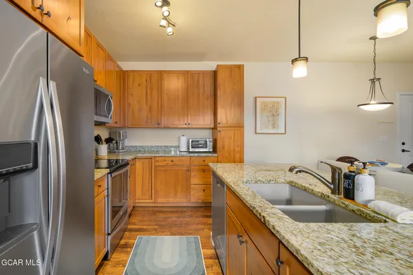 a kitchen with granite countertop a sink refrigerator and cabinets