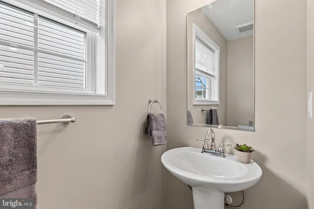 a bathroom with a sink a mirror and a window