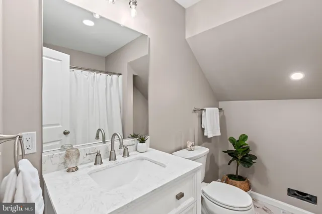 a bathroom with a double vanity sink toilet and a mirror