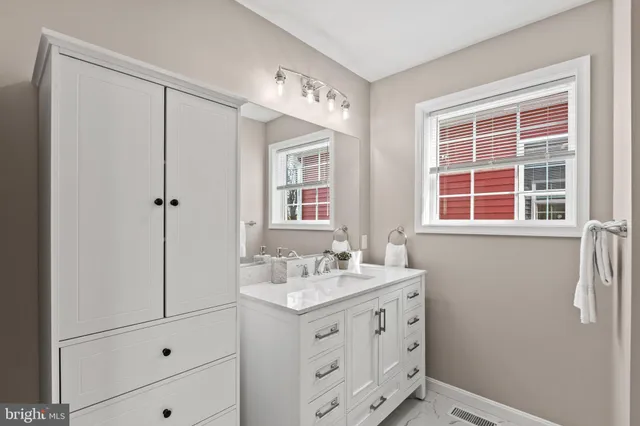 a bathroom with a sink vanity and mirror