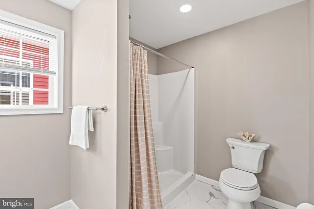 a bathroom with a toilet and a shower