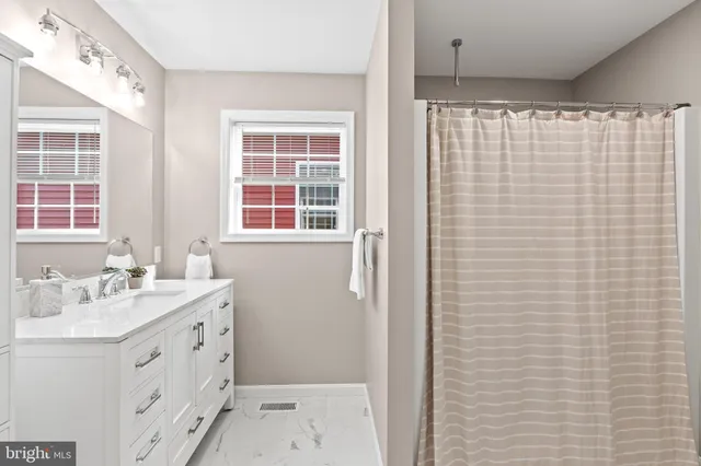 a bathroom with a sink a vanity and a shower