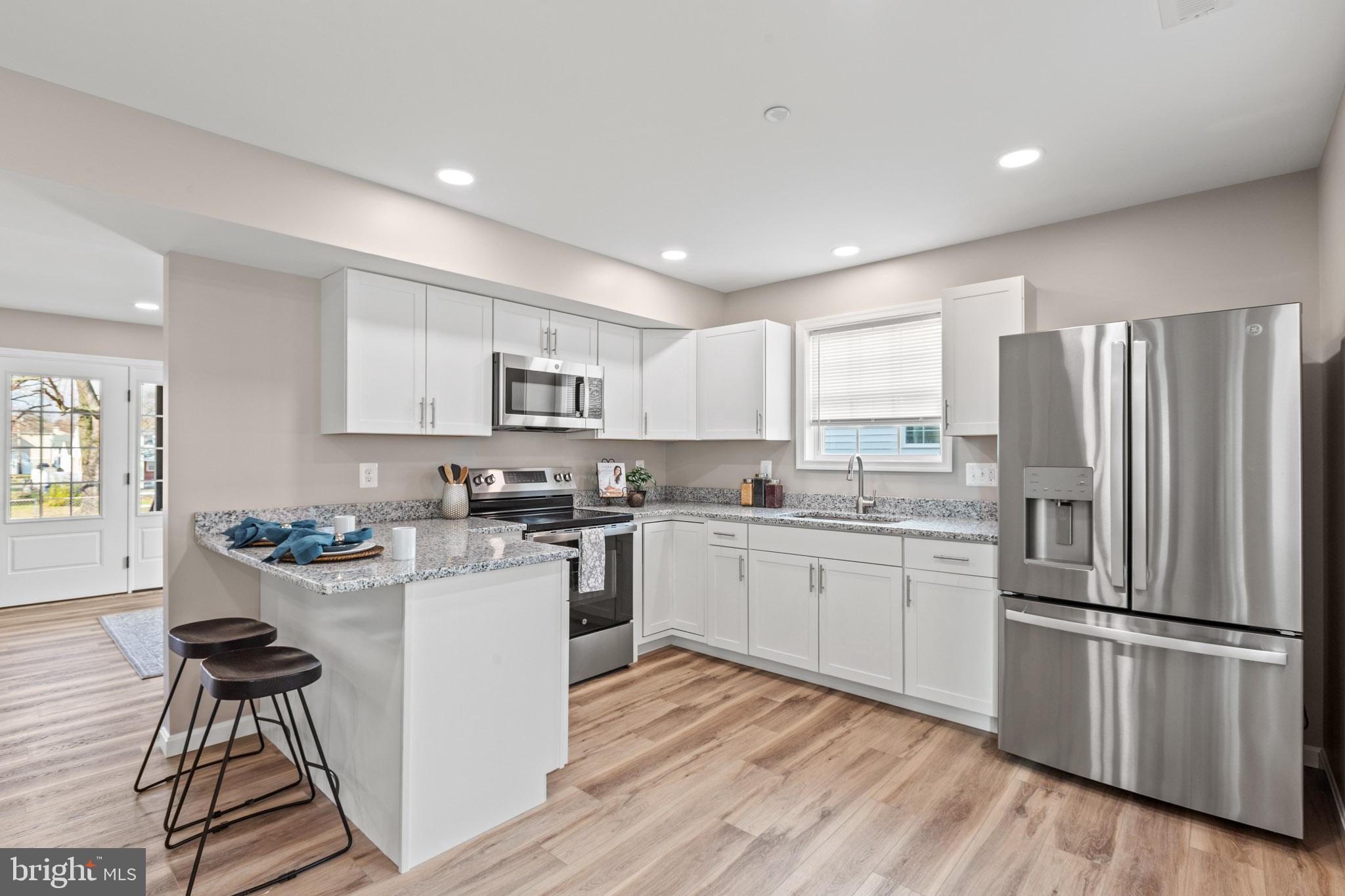 22802 Lawrence Avenue Leonardtown, MD 20650 - Photo 8 of 28 a kitchen with a sink a refrigerator and wooden floor