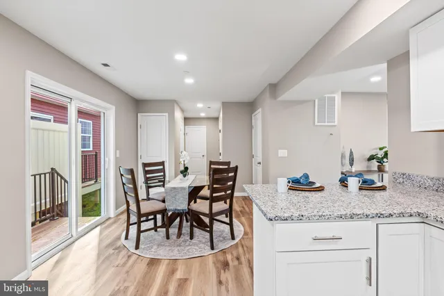 a kitchen with granite countertop sink table and chairs