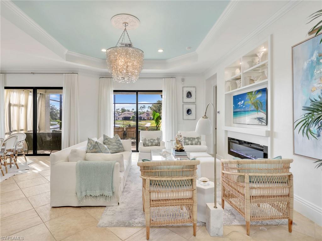 1365 Serrano Circle Naples, FL 34105 - Photo 16 of 46 Living area featuring a chandelier, a tray ceiling, crown molding, light tile patterned flooring, and recessed lighting