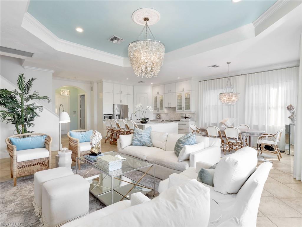 1365 Serrano Circle Naples, FL 34105 - Photo 19 of 46 Living area with a raised ceiling, a chandelier, ornamental molding, light tile patterned floors, and recessed lighting