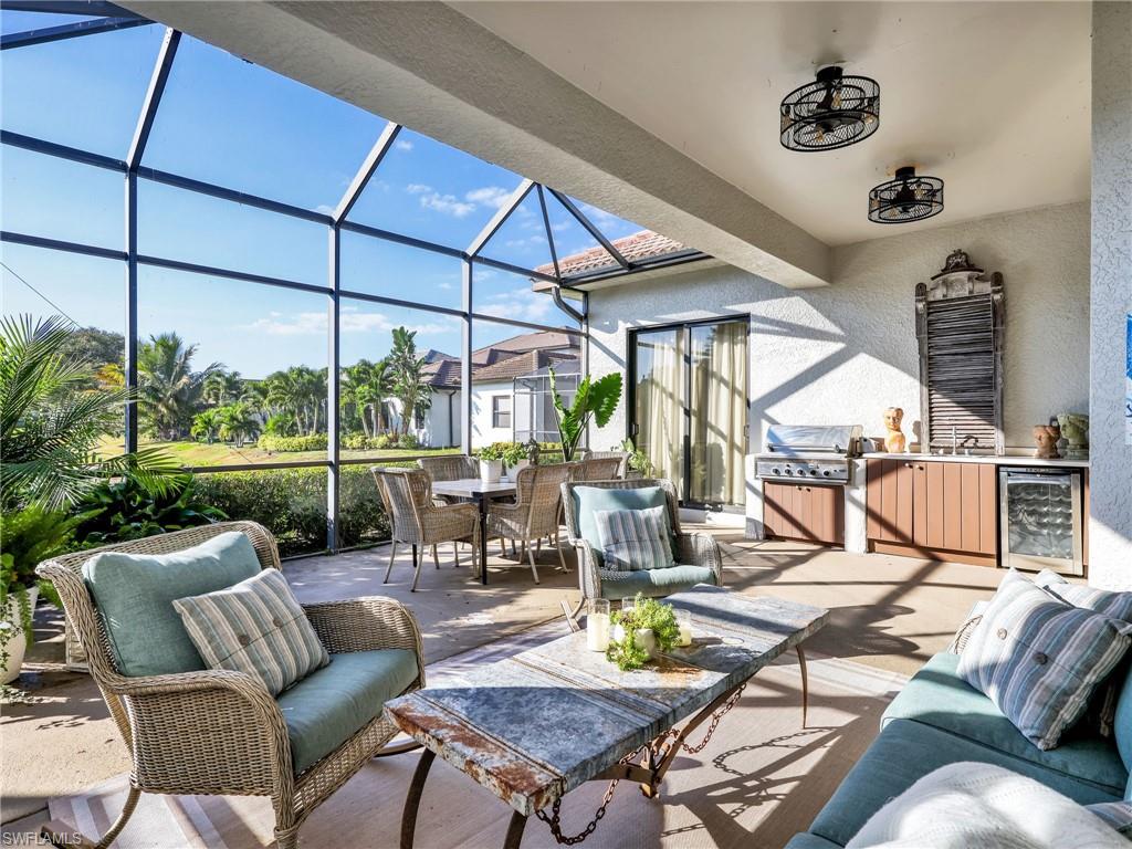 1365 Serrano Circle Naples, FL 34105 - Photo 25 of 46 View of patio / terrace with a sunroom, a lanai, wine cooler, and an outdoor living space