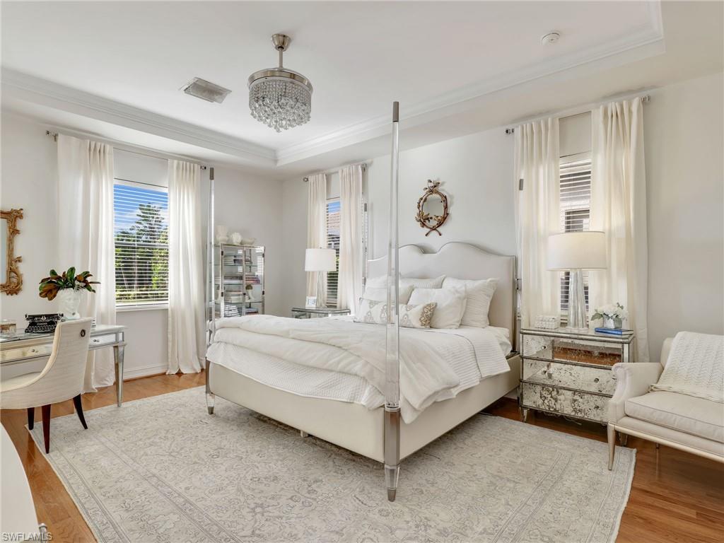 1365 Serrano Circle Naples, FL 34105 - Photo 27 of 46 Bedroom featuring a raised ceiling, wood finished floors, and crown molding