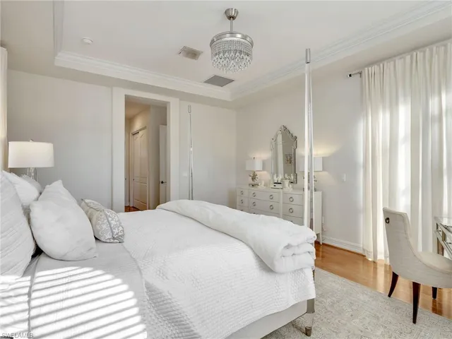 a bedroom with a large bed and a chandelier