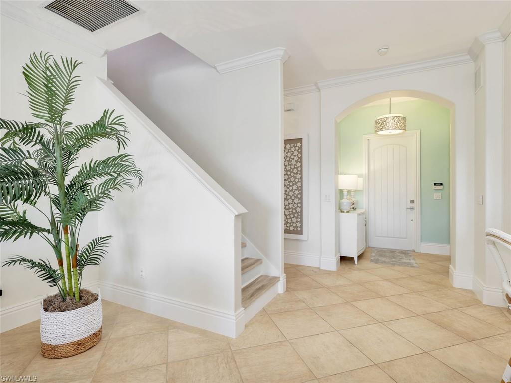 1365 Serrano Circle Naples, FL 34105 - Photo 35 of 46 Entryway featuring arched walkways, ornamental molding, stairway, and light tile patterned floors