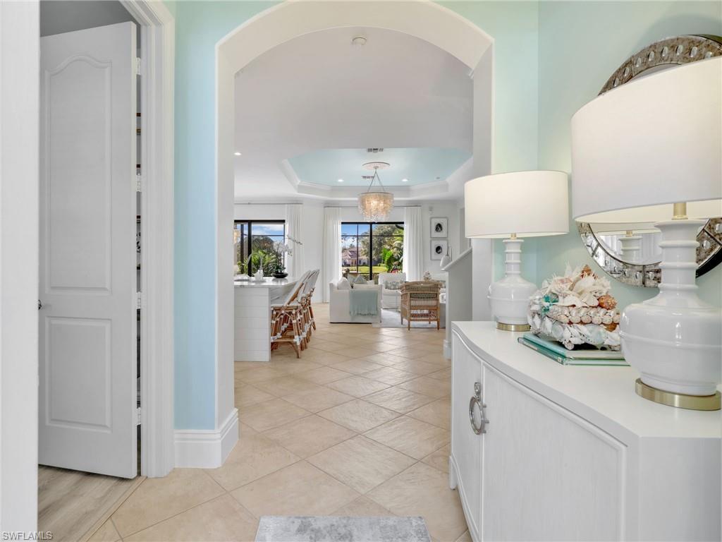 1365 Serrano Circle Naples, FL 34105 - Photo 7 of 46 Corridor featuring a tray ceiling and light tile patterned floors