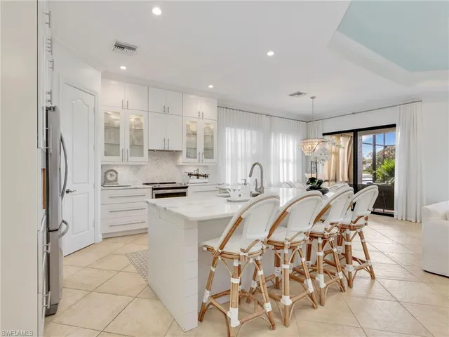 a kitchen with stainless steel appliances kitchen island granite countertop a refrigerator and a stove top oven