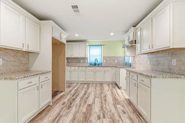 a kitchen with white cabinets appliances and a sink