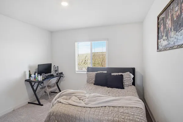 a bedroom with a bed and chair with window