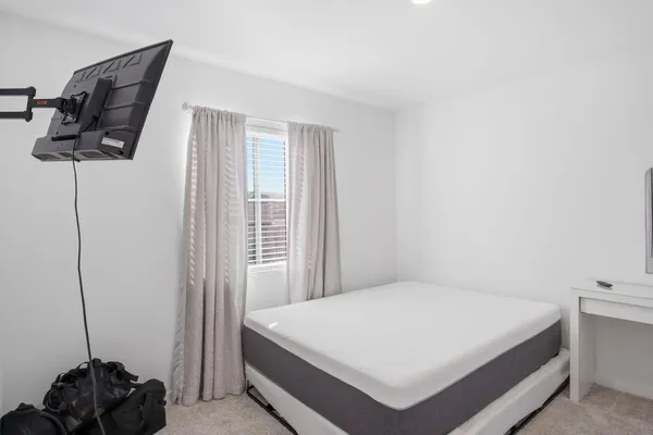 a bed sitting in a bedroom next to a window