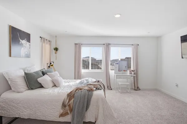 a bedroom with a bed and a large window