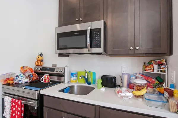a kitchen with a sink a microwave and cabinets