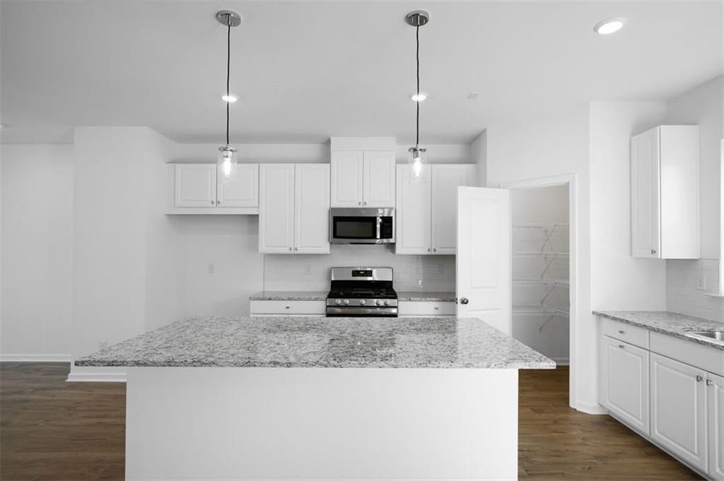 1701 Lansmere Street Southwest Marietta, GA 30008 - Photo 2 of 29 a kitchen with stainless steel appliances granite countertop a stove a refrigerator a sink and white cabinets